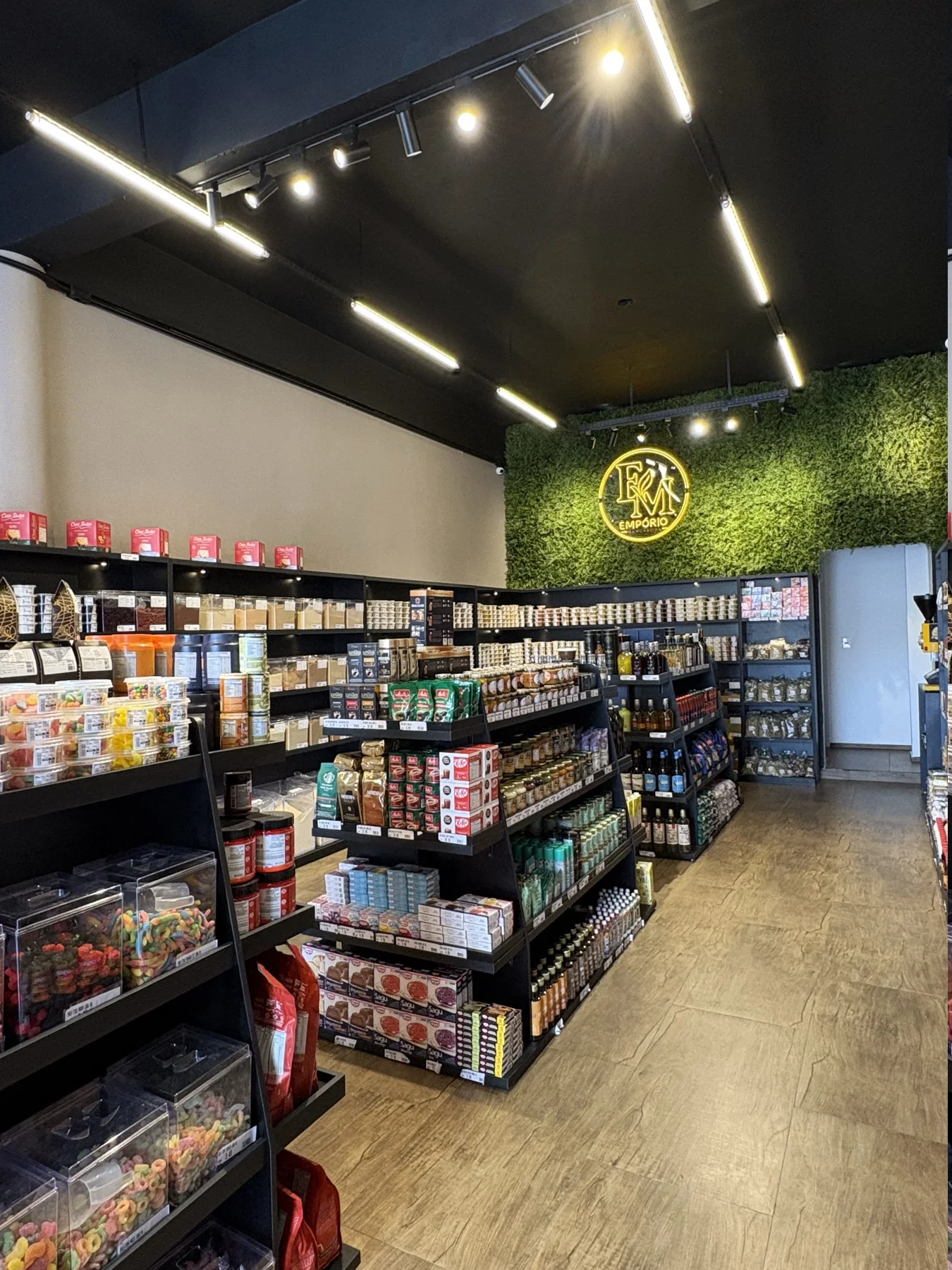 Interior do Empório Mangabeira com corredor de produtos selecionados e letreiro da marca